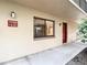 Close up of condo entry door with exterior lighting, and visible window on a well maintained walkway at 11704 Raintree Village Blvd # B, Temple Terrace, FL 33617