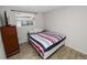 Cozy bedroom with a striped bedspread, wood-look tile flooring, and a window with blinds for natural light at 1317 E Laura St, Plant City, FL 33563