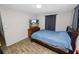 Well-lit bedroom featuring wood floors, a blue bedspread, television, and window with curtains at 1317 E Laura St, Plant City, FL 33563