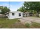 Side exterior view of single-story home with attached carport and mature trees at 1317 E Laura St, Plant City, FL 33563
