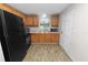 Bright kitchen featuring wood cabinets, black appliances, and wood-look laminate floors at 1317 E Laura St, Plant City, FL 33563