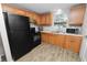 Functional kitchen with black appliances, oak cabinets, and laminate flooring at 1317 E Laura St, Plant City, FL 33563