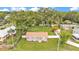Aerial view of a grey home with a large yard and mature trees, nestled in a quiet neighborhood at 1603 N Park Rd, Plant City, FL 33563