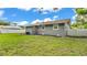 Backyard featuring a white fence, green lawn, neutral colored house, and trimmed hedges at 1603 N Park Rd, Plant City, FL 33563