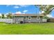 Backyard featuring a white fence, green lawn, neutral colored house, and trimmed hedges at 1603 N Park Rd, Plant City, FL 33563