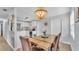 Bright dining room with wooden table, chandelier, seamlessly connected to the kitchen with white cabinetry at 1603 N Park Rd, Plant City, FL 33563