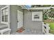 Charming entrance featuring a tiled porch, white door, and neutral gray siding at 1603 N Park Rd, Plant City, FL 33563