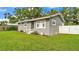 Gray single-story home showcasing a neat lawn with clean, white fence at 1603 N Park Rd, Plant City, FL 33563