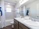 Well-lit bathroom features double sinks, a vanity with marble countertops, and a tiled shower/tub, perfect for relaxation at 35444 Darlington Grove Dr, Zephyrhills, FL 33541