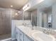 Modern bathroom featuring double sinks, sleek vanities, a glass-enclosed shower and neutral-toned tiles for a spa-like retreat at 35444 Darlington Grove Dr, Zephyrhills, FL 33541
