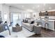Open-concept living area with modern furnishings, ample natural light, and seamless flow to the kitchen and outdoor space at 35444 Darlington Grove Dr, Zephyrhills, FL 33541
