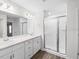 Bright bathroom featuring double sinks, quartz countertops, and large glass enclosed shower at 35452 Darlington Grove Dr, Zephyrhills, FL 33541