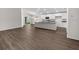 Bright, open-concept living space with kitchen island and sliding doors to a scenic lake view at 35452 Darlington Grove Dr, Zephyrhills, FL 33541