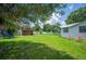 Expansive backyard with lush green grass, a shed, and a vibrant blue slide for outdoor enjoyment at 3611 Maxwell Rd, Plant City, FL 33566