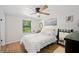 Bright bedroom with hardwood floors, a ceiling fan, and a view of a green backyard at 3611 Maxwell Rd, Plant City, FL 33566