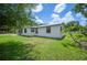 Side view of the home showcasing the clean white exterior, well-maintained lawn, and meticulous landscaping at 3611 Maxwell Rd, Plant City, FL 33566