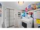 Functional laundry room featuring a washer, dryer, and shelving for ample storage and organization at 3611 Maxwell Rd, Plant City, FL 33566