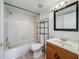 This bathroom features tub/shower combo, wooden vanity and ample storage shelves at 4022 Tumble Wood Trl # 101, Tampa, FL 33613
