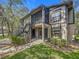 Two-story condo with black trim and railings and well-maintained landscaping under a clear blue sky at 4022 Tumble Wood Trl # 101, Tampa, FL 33613