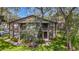 Two-story condo with mature trees, black railings, and well-maintained landscaping on a sunny day at 4022 Tumble Wood Trl # 101, Tampa, FL 33613