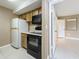 Cozy kitchen featuring wooden cabinetry, black appliances, and tile flooring at 4022 Tumble Wood Trl # 101, Tampa, FL 33613