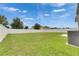 Spacious backyard enclosed by a white fence, featuring lush green grass and ample space for recreation and relaxation at 503 Arbequina Ct, Plant City, FL 33566