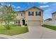 Inviting two-story home featuring a two-car garage and manicured front lawn at 503 Arbequina Ct, Plant City, FL 33566