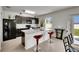 Modern kitchen with stainless appliances, bar seating, and view to fenced yard at 503 Arbequina Ct, Plant City, FL 33566