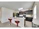 Modern kitchen with island, gray cabinets, granite countertops, and red bar stools at 503 Arbequina Ct, Plant City, FL 33566