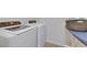 Functional laundry room with a washing machine, dryer, and ironing board at 503 Arbequina Ct, Plant City, FL 33566