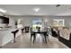 Open-concept living space featuring dining table, kitchen bar, and comfortable living room seating at 503 Arbequina Ct, Plant City, FL 33566
