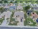 Aerial view of a charming home with well-manicured landscaping, screened pool, and a brick driveway at 2024 E Del Webb Blvd, Sun City Center, FL 33573