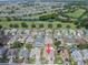 This aerial view shows a home with manicured landscaping in a community near a lush golf course and scenic pond at 2024 E Del Webb Blvd, Sun City Center, FL 33573
