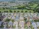 This aerial view shows a home with manicured landscaping in a community near a lush golf course and scenic pond at 2024 E Del Webb Blvd, Sun City Center, FL 33573