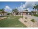 Charming single-story home featuring a well-manicured lawn, lush landscaping, and a paver driveway leading to a two-car garage at 2024 E Del Webb Blvd, Sun City Center, FL 33573