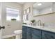 Updated bathroom with blue vanity cabinet, marble countertop, and modern fixtures at 2306 33Rd W St, Bradenton, FL 34205
