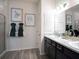 Elegant bathroom with double sinks, dark cabinetry, and modern fixtures at 35392 Coventry Fields Loop, Zephyrhills, FL 33541