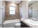 Well-lit bathroom with a tub/shower combo, ceramic tile surround, and a dark vanity at 35402 Coventry Fields Loop, Zephyrhills, FL 33541