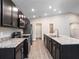 Bright kitchen featuring stainless steel appliances, dark cabinets, an island and an open concept design at 35402 Coventry Fields Loop, Zephyrhills, FL 33541