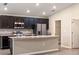 Modern kitchen featuring stainless steel appliances, dark cabinets, an island and an open concept design at 35402 Coventry Fields Loop, Zephyrhills, FL 33541