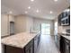 Modern kitchen featuring stainless steel appliances, dark cabinets, an island and an open concept design at 35402 Coventry Fields Loop, Zephyrhills, FL 33541