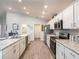 Modern kitchen featuring stainless steel appliances, granite countertops, sleek white cabinetry, and wood-look floors at 35494 Coventry Fields Loop, Zephyrhills, FL 33541