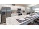 Bright kitchen features stainless steel appliances, counter seating, granite countertops, and pendant lighting at 35494 Coventry Fields Loop, Zephyrhills, FL 33541