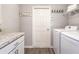Functional laundry room with overhead shelving, a countertop for folding, a washer, and a dryer at 35494 Coventry Fields Loop, Zephyrhills, FL 33541