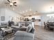 Open-concept living space with modern furnishings, wood-look flooring, recessed lighting, and seamless kitchen access at 35494 Coventry Fields Loop, Zephyrhills, FL 33541
