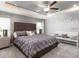Comfortable main bedroom with a tray ceiling, ceiling fan, a bench, and plush carpeting at 35494 Coventry Fields Loop, Zephyrhills, FL 33541