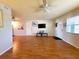 Open-concept living room with wood flooring, TV, and a ceiling fan, perfect for relaxation and entertainment at 1893 Shore S Dr # 208, South Pasadena, FL 33707