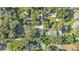 Aerial view reveals a pool, surrounding trees, and nearby residences, capturing a peaceful neighborhood setting at 4818 Huron St, Zephyrhills, FL 33541