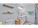 Cozy bathroom with floating wood shelves, a toilet, and a vanity at 4818 Huron St, Zephyrhills, FL 33541