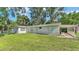 Exterior view of a light gray home with a well-manicured lawn at 4818 Huron St, Zephyrhills, FL 33541